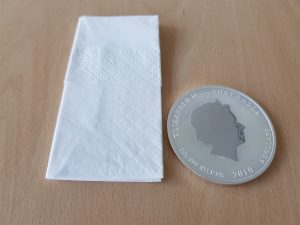Größenvergleich: Taschentuch und Silbermünze Lunar II 2oz